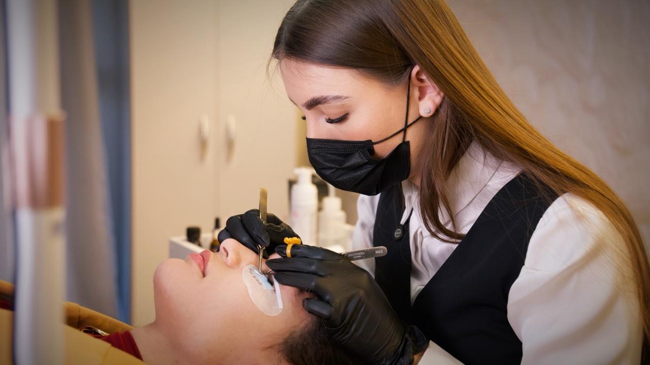 Camila Esser aplicando extensão de cílios em uma cliente